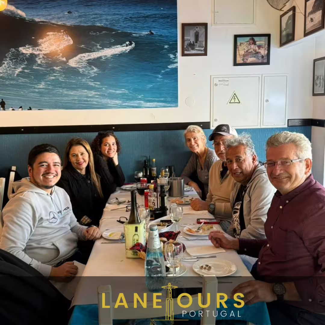 Tour group enjoying a meal together in a cozy Portuguese restaurant, highlighting the cultural experience of the guided tour.