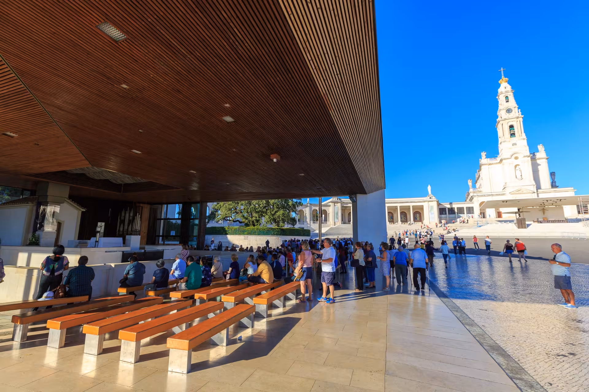 Pilgrims gather at the Sanctuary of Fátima with the Basilica in the background, part of Lisbon half-day tour experience.