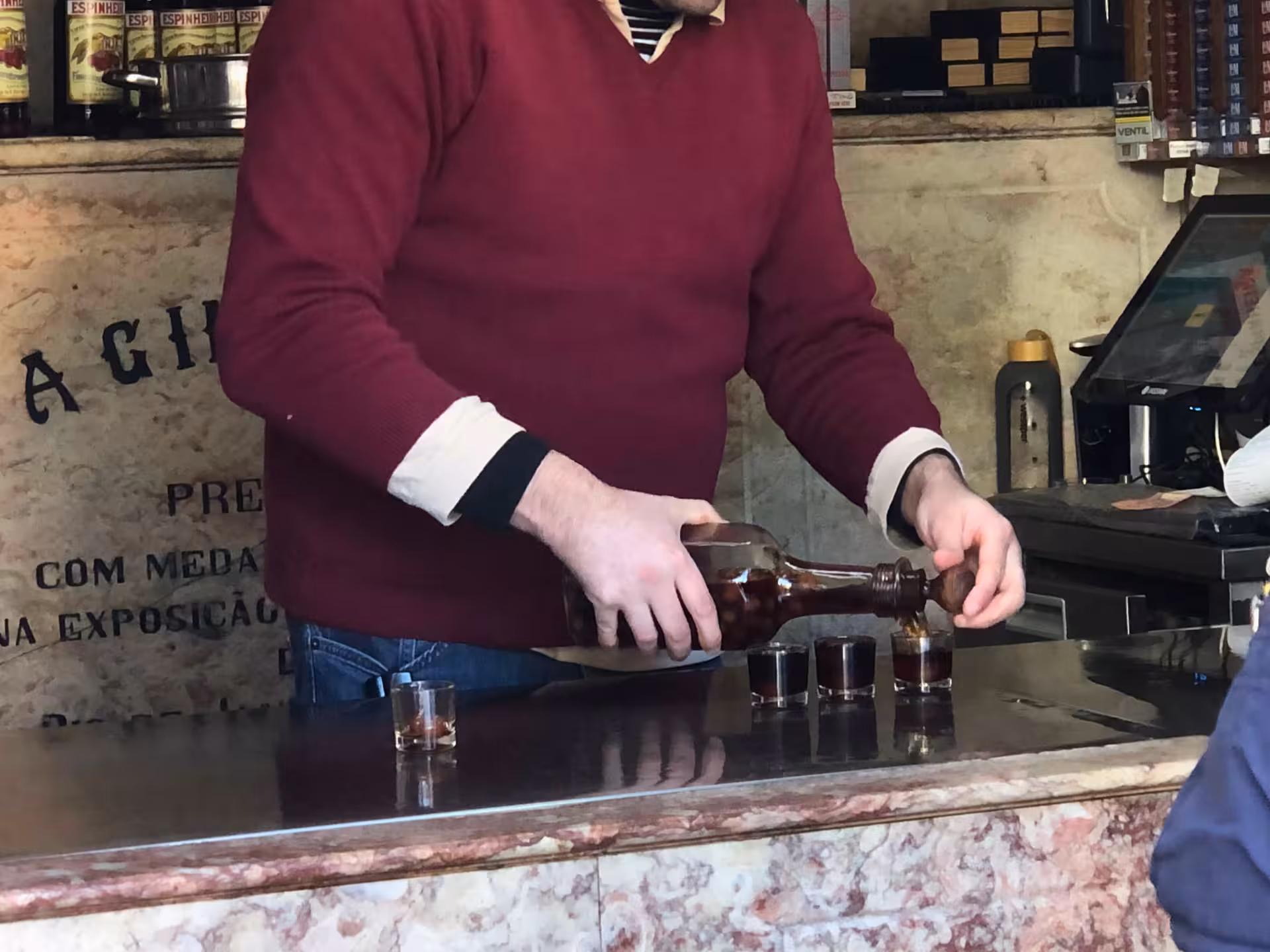 Bartender pouring ginjinha shots at a historic Lisbon bar on Old Shops, Traditions & Stories tour