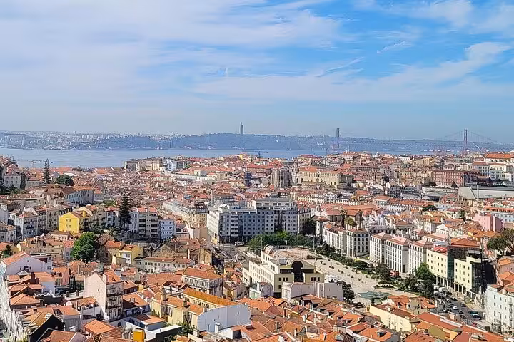 Panoramic viewpoint over Lisbon historic center with Tagus River and 25 de Abril Bridge on a private tuk tuk tour