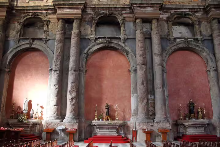 Historic Lisbon church interior with grand arches and statues, part of a full-day private tour and culinary experience.