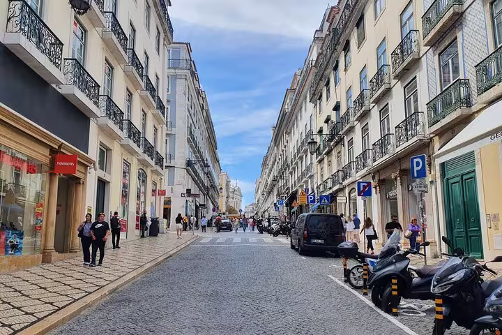Scenic view of a bustling Lisbon street showcasing historic architecture, lively pedestrian activity, and vibrant city life.