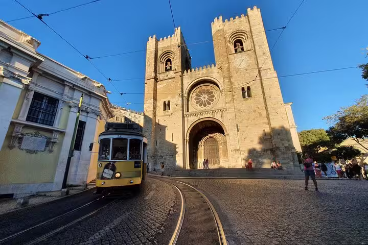 Historic tram passing by Lisbon Cathedral, a highlight of the Lisboa Old Town, New Town & Belem Private Full-Day Tour.