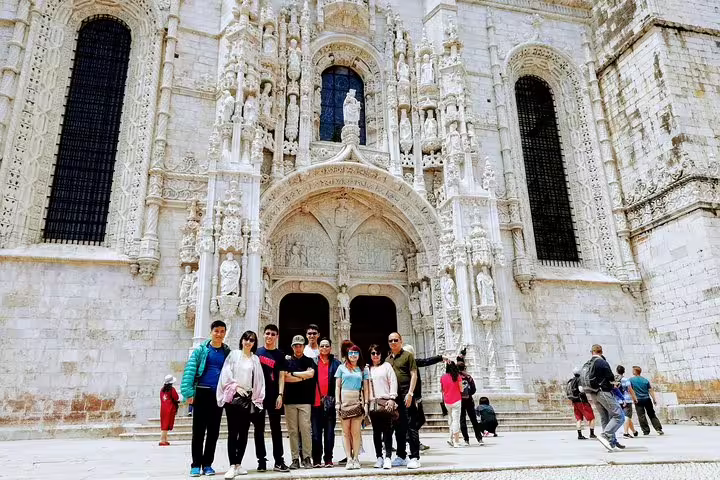 Tourists explore the intricate Manueline architecture of Jerónimos Monastery on a Lisbon World Heritage guided tour.