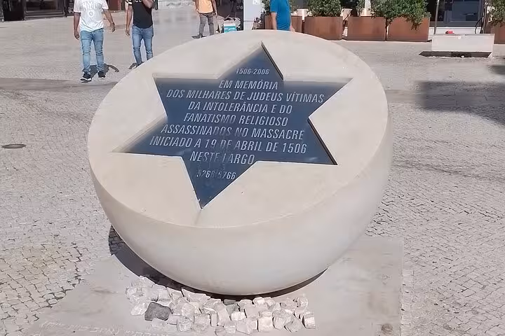 Memorial in Lisbon honoring Jewish victims of the 1506 massacre, featuring a star-shaped inscription on a sculpted stone.