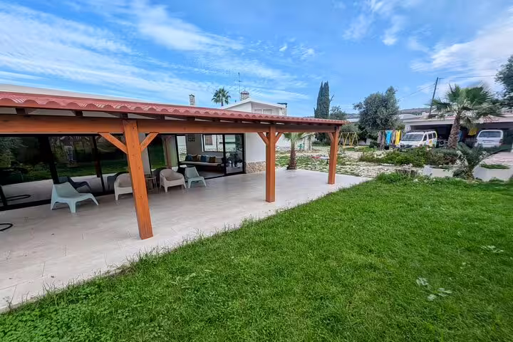 Charming outdoor patio with seating under a wooden pergola, perfect for relaxing before or after the Lisbon kayak adventure.
