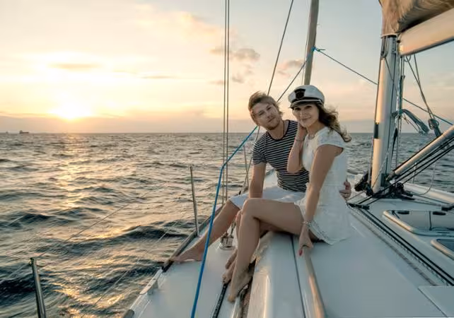 Couple relaxing on a luxury sailboat at sunset on the Tagus River, Lisbon romantic cruise experience