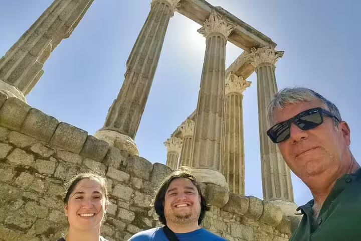 Travelers enjoying the ancient Roman Temple of Évora during a scenic Lisbon to Madrid private transfer with stops.