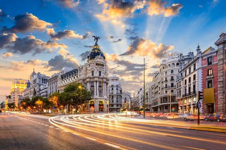Bustling Madrid street with stunning architecture and vibrant lights, highlighting Lisbon to Madrid private transfer experience.