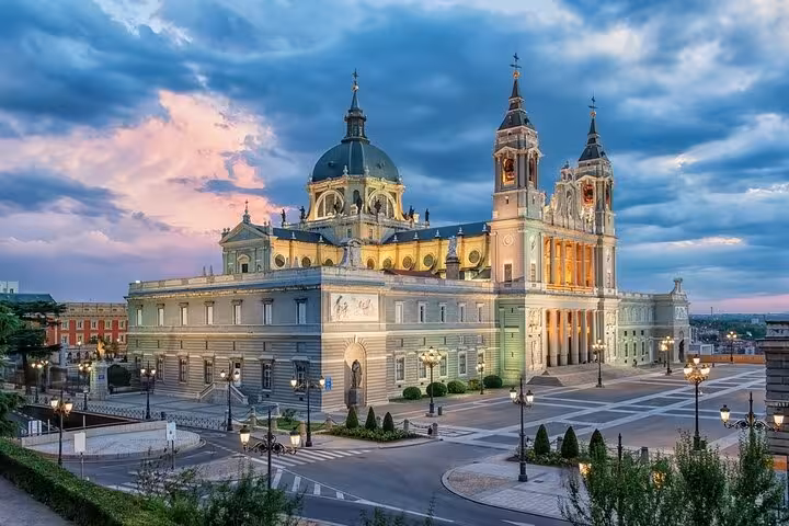 Stunning view of Madrid's Almudena Cathedral at sunset, a key landmark on the Lisbon to Madrid private transfer journey.
