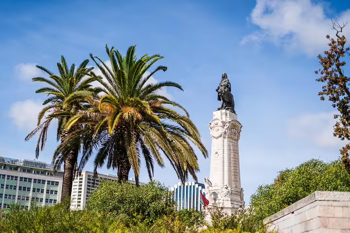 View of Lisbon's Marques de Pombal monument surrounded by lush palm trees, ideal for a private half-day historic tour.