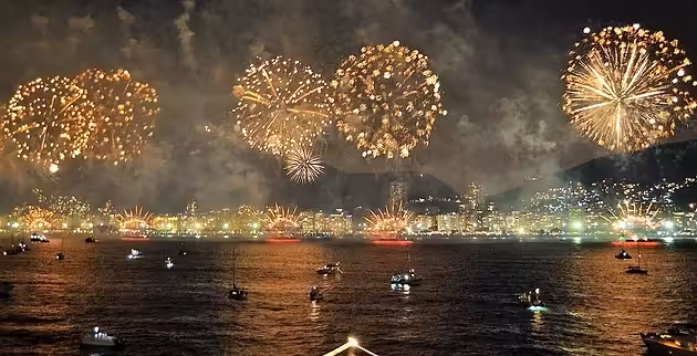 Lisbon New Year’s Eve fireworks over the Tagus River, viewed from a VIP catamaran cruise with city lights