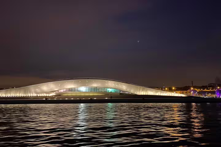 Stunning night view of Lisbon's modern waterfront architecture seen from a sailing tour on the Tagus River.