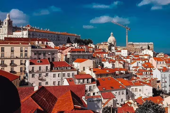 Enjoy panoramic views of Lisbon's red-roofed buildings and historic landmarks on a captivating tuk tuk tour of the Old Town.