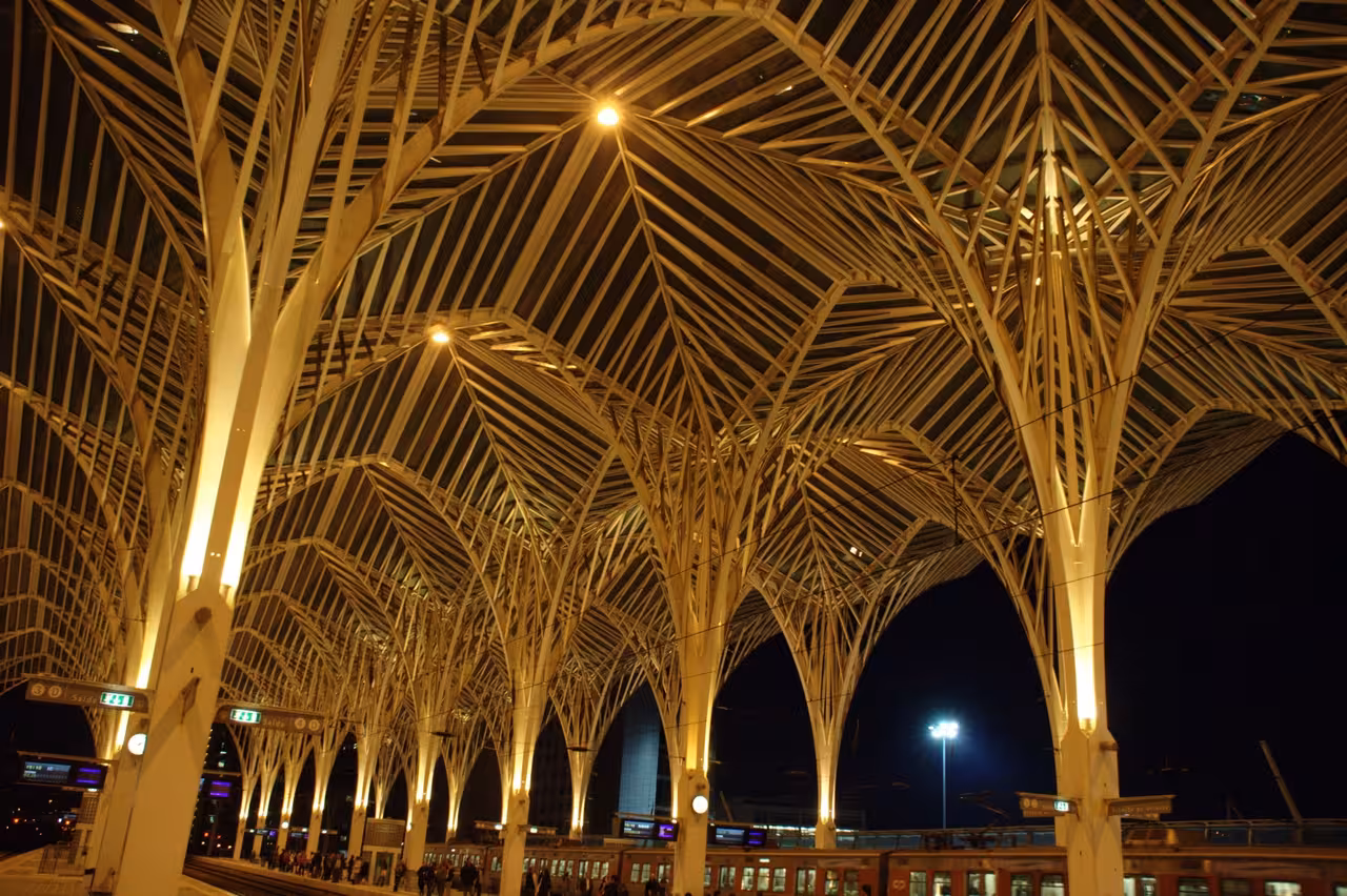 Illuminated night view of Lisbon's Oriente Station showcasing its striking modern architectural design.