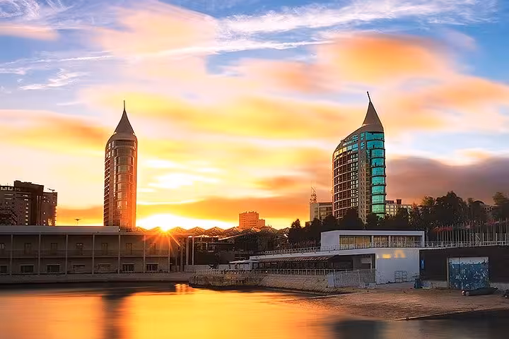 Stunning sunset over Lisbon's Parque das Nações, showcasing vibrant skies and contemporary architectural towers.