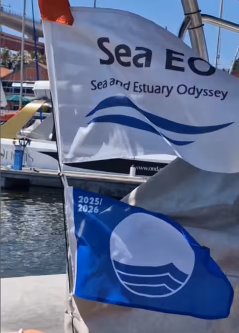 Sea EO and Blue Flag banners on boat at Lisbon marina for plastic pickup and eco boat tour on Tagus River