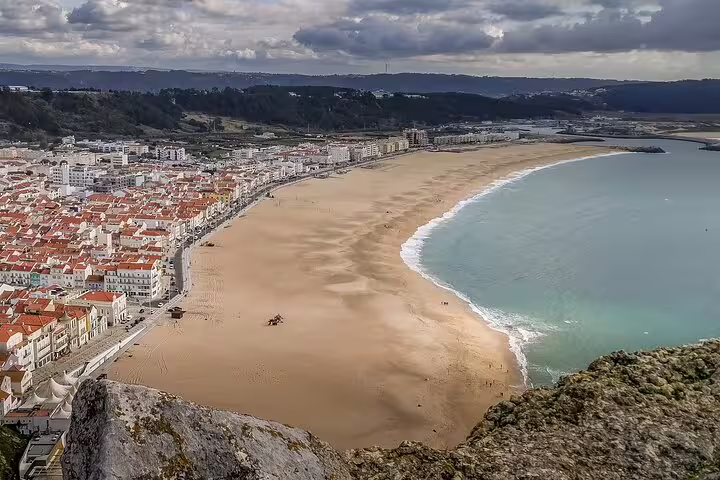 Aerial view of a stunning coastal beach town in Portugal, ideal for a 2-day private tour from Lisbon to Porto, showcasing scenic landscapes.