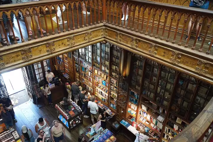 Charming interior of a historic bookstore visited on a private tour from Lisbon to Porto, featuring ornate wooden architecture and book displays.