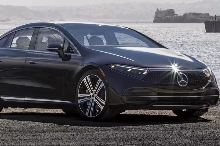 Luxurious black car parked by the scenic waterfront, perfect for a private Lisbon to Porto journey with customizable stops.