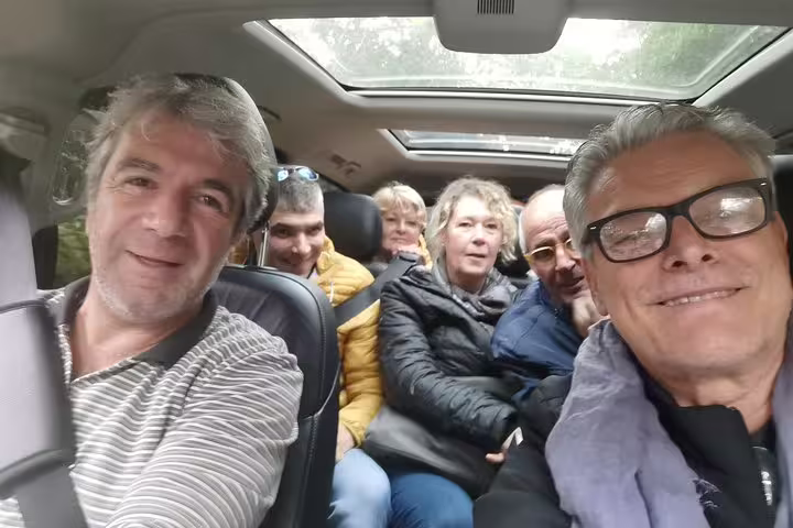 Group enjoying a scenic road trip from Lisbon to Porto with stops in Obidos, Nazare, and Alcobaca, inside a comfortable vehicle.
