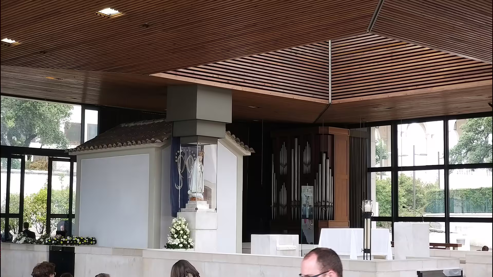 Modern chapel interior with religious statue and elegant wooden ceiling, part of the Private Lisbon to Porto Tour experience.