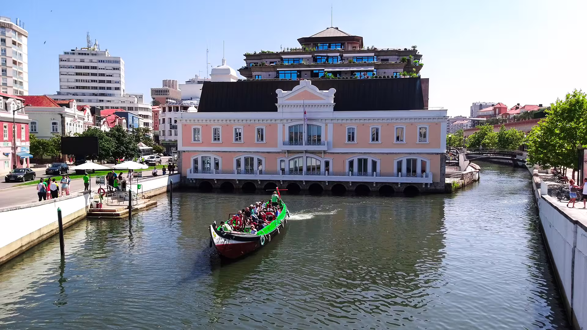 Colorful boat cruising a canal in picturesque Portuguese town, highlighting the charm of a private Lisbon to Porto tour adventure.