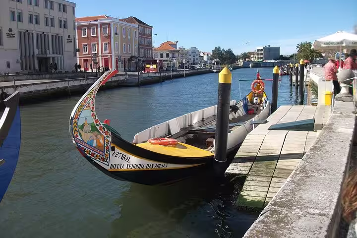 Colorful traditional boat docked along the scenic canals of Aveiro, perfect for a Lisbon to Porto transfer stop.