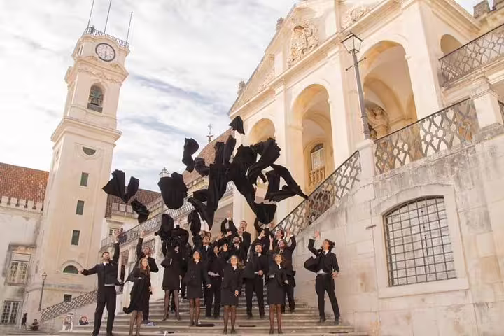 Students celebrate on the historic steps of the University of Coimbra during the Lisbon to Porto transfer tour.