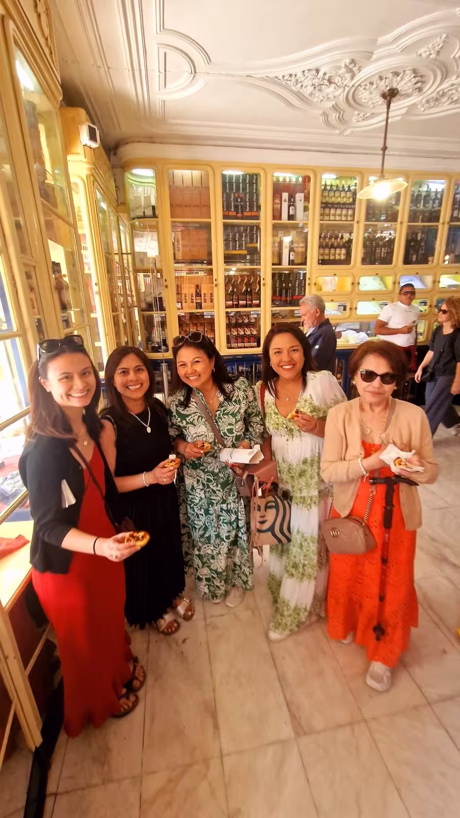 Visitors savor traditional Portuguese pastries inside a charming Lisbon shop, experiencing local culture and cuisine.