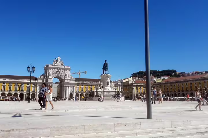 Praça do Comércio in Lisbon features the iconic Arco da Rua Augusta and a statue of King José I under a clear blue sky.