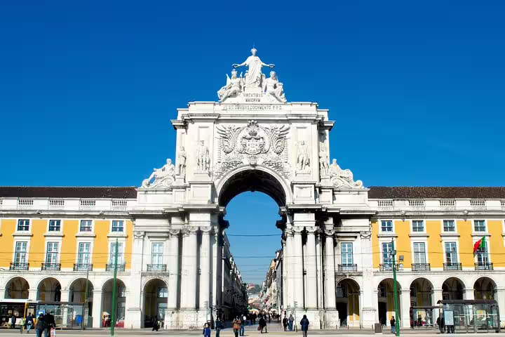 Triumphal arch at Praça do Comércio on a sunny day, featured in Lisbon full-day private tour with premium vehicle and custom stops.