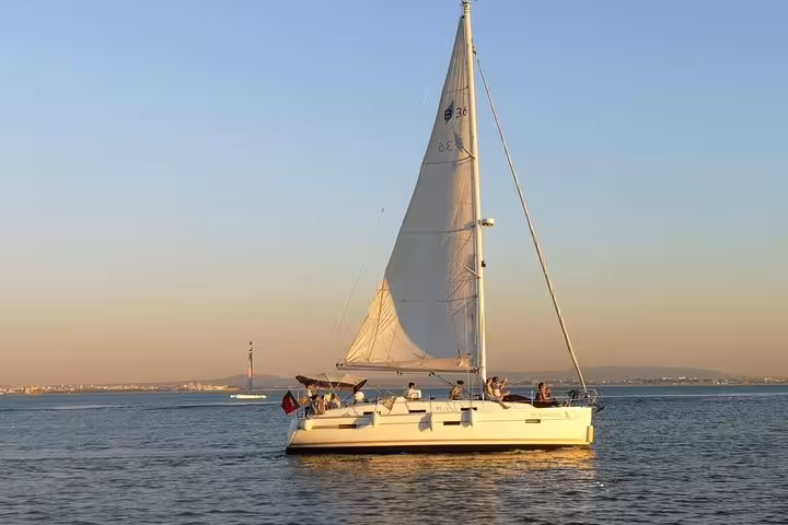 Private sailing cruise on the Tagus River in Lisbon at sunset, yacht with guests and drink included