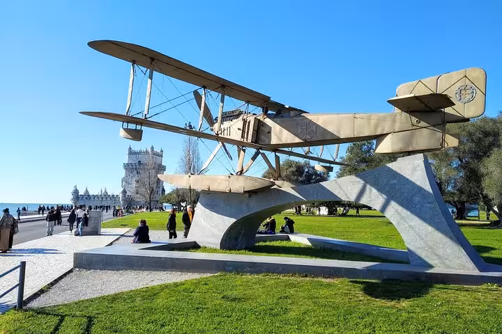Monument of a vintage aircraft near the iconic Belém Tower, a highlight on the Lisbon private tour.