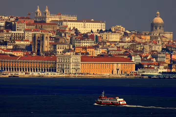 Scenic view of Lisbon's historic architecture and waterfront with a ferry, perfect for a private full-day premium tour.