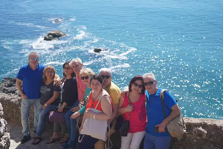 A group of tourists enjoys a scenic ocean view during a full-day private tour from Lisbon to Óbidos, Nazaré, and Fátima.