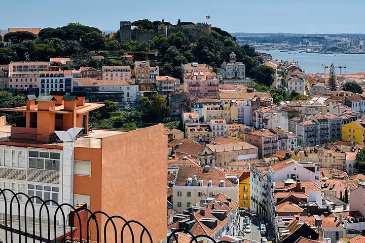 Scenic view of Lisbon's vibrant architecture and historical São Jorge Castle overlooking the Tagus River.