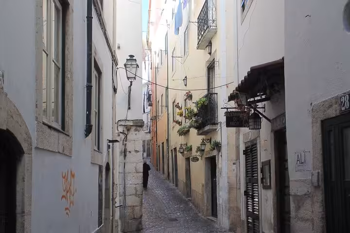 Explore Lisbon's charming narrow cobblestone streets lined with historic buildings on a private walking tour.