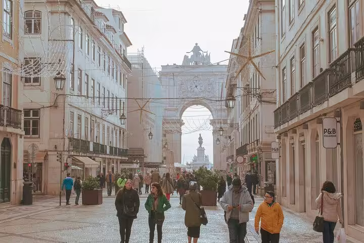 Stroll through Lisbon's bustling streets towards Rua Augusta Arch on a private walking tour, capturing the city's lively atmosphere.