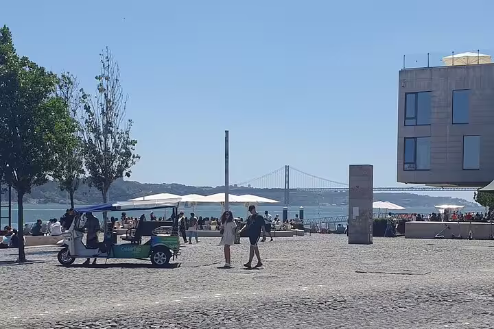 Ribeira das Naus waterfront plaza with 25 de Abril Bridge views, perfect stop on Lisbon GPS audio tour