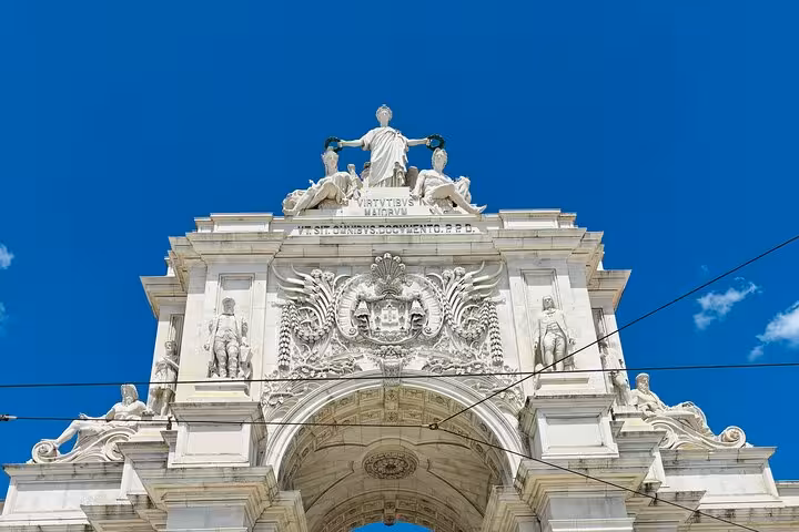 Discover Lisbon's iconic Rua Augusta Arch with intricate sculptures on a private tour under a clear blue sky.