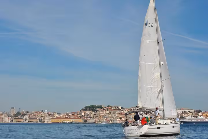 Small group sailing yacht cruising past Lisbon old town waterfront on the Tagus River, 2-hour tour with drink