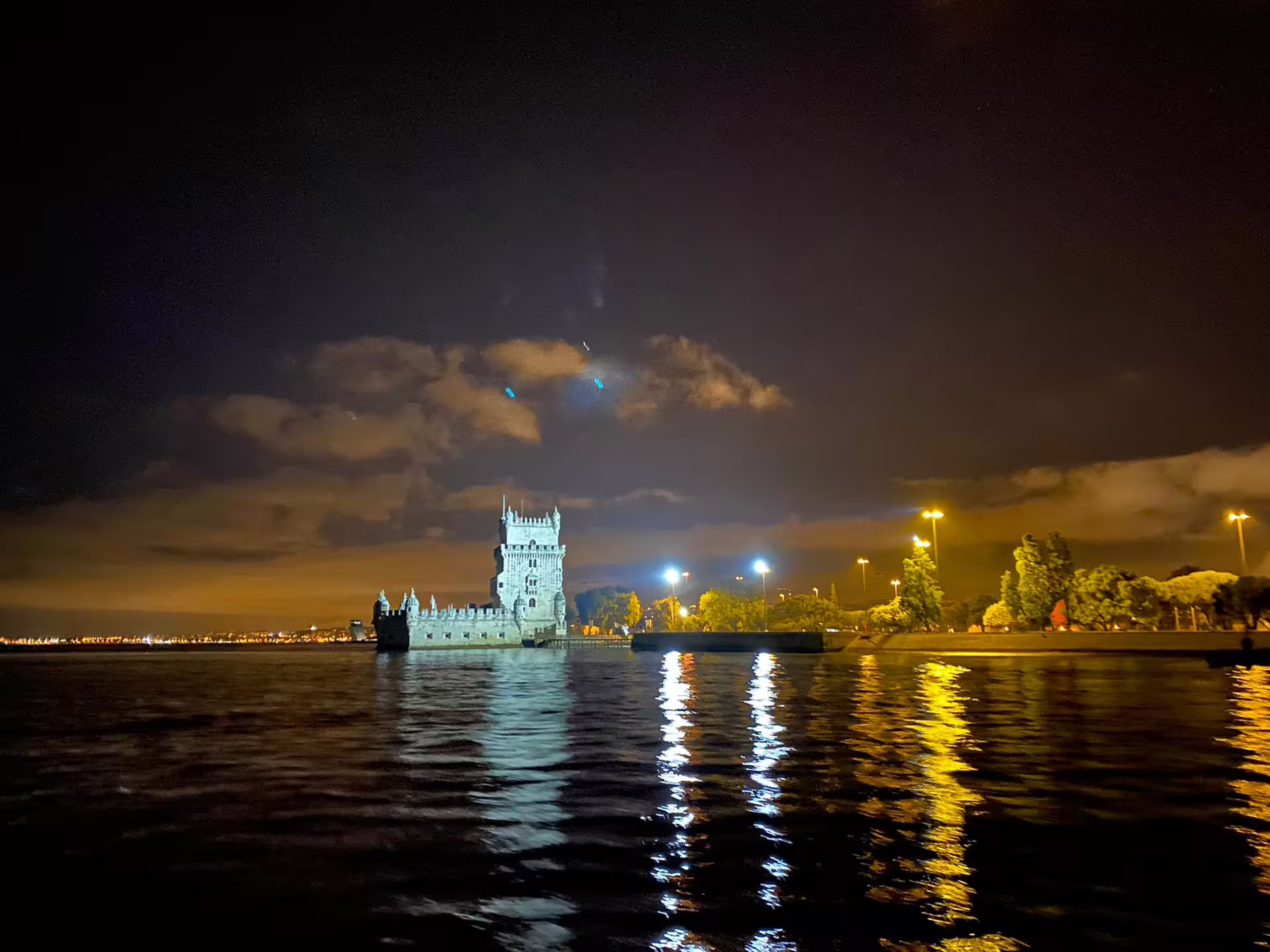 Night view of Belem Tower from the water, a highlight on the Lisbon Sailing Tour by Night.