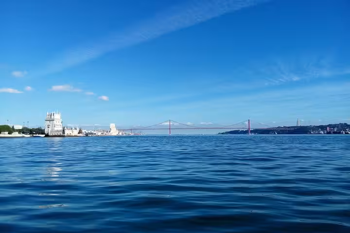 Tagus River view on a private Lisbon sailing yacht cruise, with Belém Tower and the 25 de Abril Bridge ahead