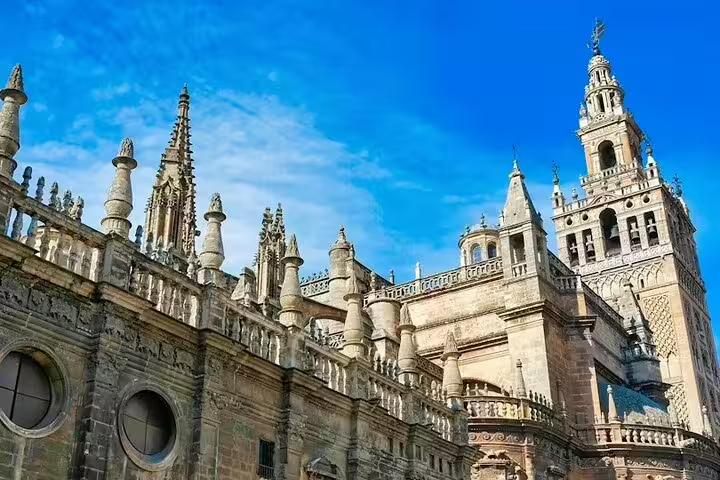 Majestic view of Seville Cathedral's intricate Gothic architecture under a clear blue sky, featured on the Lisbon to Seville private tour.