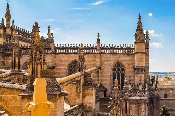Gothic architecture of Seville Cathedral under blue skies, featured in Lisbon to Seville private journey direct route tour.
