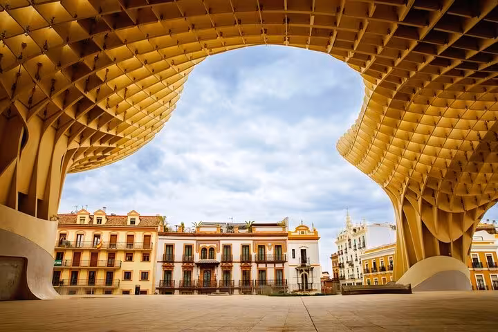 View of Seville's Metropol Parasol with traditional buildings underneath, highlighting modern architecture and cultural fusion.