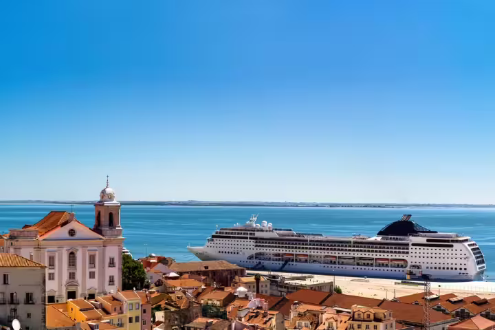 Panoramic view of Lisbon's historic Alfama district with a cruise ship docked, perfect for shore excursions to Sintra and Estoril.