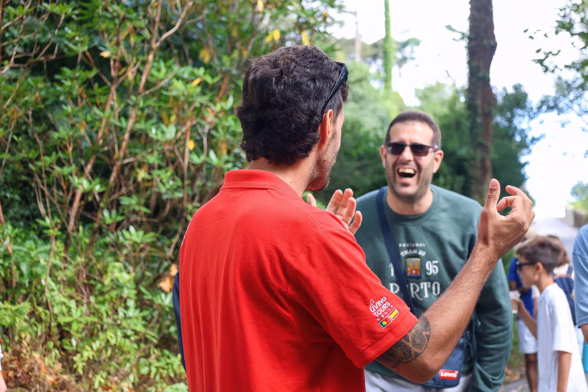Tour guide engaging with smiling tourists on a lush green path in Sintra during a small group tour.