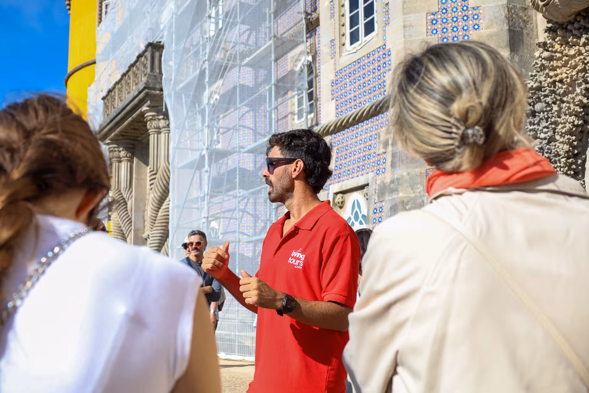 A tour guide leads a group at the vibrant Pena Palace in Sintra, highlighting its rich details.
